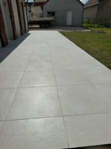 Terrasse extérieure surélevée en béton et carrelage blanc